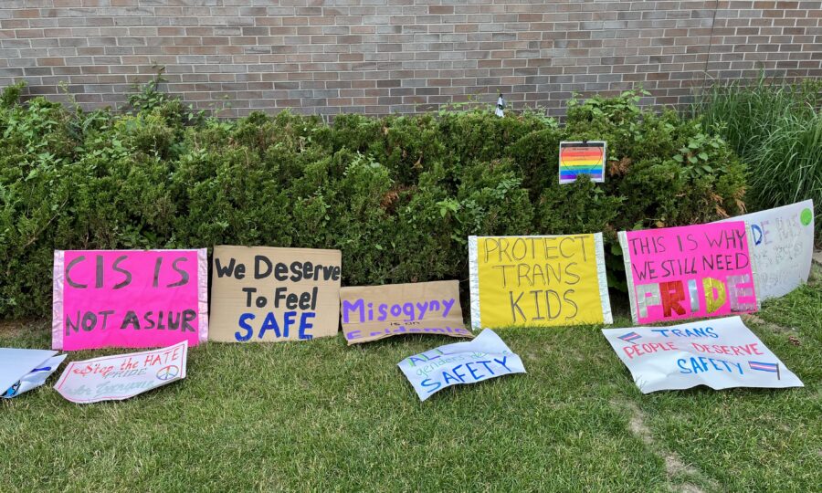 Hand-made signs placed on the lawn outside a building.